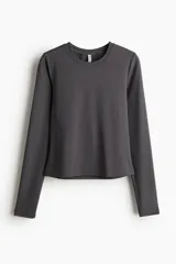 Remera gris oscuro corta de microfibra suave, de ajuste entallado, con cuello redondo ribeteado y mangas largas.