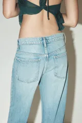 Pantalón de jean azul oscuro, de corte wide leg y tiro medio, con cinco bolsillos y cierre frontal con cremallera y botón metálico.