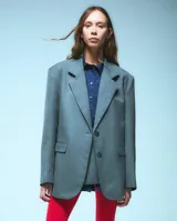 Saco sastrero oversize color gris, abotonado en el frente con bolsillos delanteros y bordado en tapa de bolsillo.