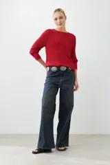 Sweater rojo de tejido de punto con ruedo curvo y mangas 3/4.