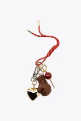 Llavero con cordón rojo y charms colgantes: corazón dorado, guante de boxeo marrón y esfera roja.