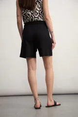 Short de vestir color beige claro, tiro alto, con pliegues frontales y lazo para ajustar la cintura.