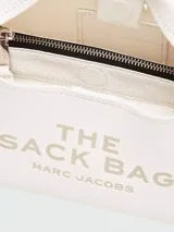 Bolso blanco tipo hobo, modelo The Mini Sac Bag de Marc Jacobs, con asas cortas y texto estampado en el frente.