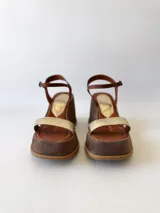 Sandalias de cuero con plataforma, color marrón con tira dorada sobre los dedos y tobillera marrón con hebilla.