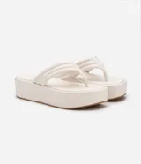 Sandalia tipo ojota de la marca Satinato con plataforma plana de 5 cm. Cuenta con tiras anchas acolchadas con costuras decorativas tipo capitoneado y puntera redonda.