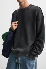 Sweater negro de algodón con cuello redondo, manga larga y terminaciones en rib.