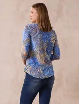 Blusa de modal estampada con motivos paisley en tonos azules, naranjas y amarillos. Tiene escote redondo y mangas tres cuartos.