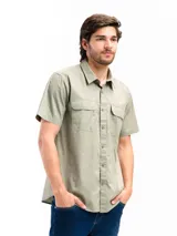 Camisa de manga corta color beige con cuello clásico, cierre frontal con botones, dos bolsillos con solapa abotonada en el pecho y corte recto. Ideal para actividades al aire libre.