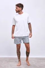 Short de baño celeste con estampado de flores rojas y hojas verdes.