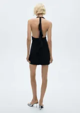 Vestido corto negro con cuello halter, espalda descubierta, tejido fruncido y cierre de lazo en el cuello.