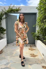 Vestido corto con estampado abstracto en tonos beige, naranja, verde y negro.