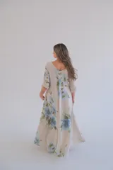 Vestido largo color beige con estampado de flores azules, corte amplio, escote en V y mangas 3/4.