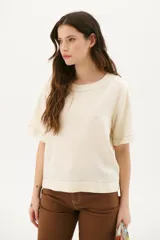 Blusa color crudo de lino con cuello redondo y mangas cortas.