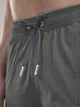 Short de baño verde oliva con cintura elástica ajustable con cordón, bolsillos laterales y un bolsillo trasero con ojal de drenaje.