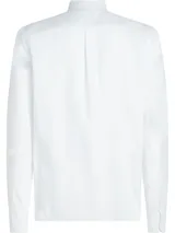 Camisa blanca de corte regular, confeccionada en tejido Oxford Dobby de mezcla de algodón. Tiene cuello abotonado, cierre con botones, manga larga y logo de Tommy Hilfiger bordado en el pecho.