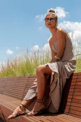 Vestido largo color gris con breteles finos y escote con cordones.