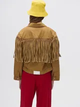 Campera de jean marrón claro con flecos en el pecho y mangas.