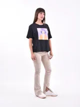 Remera color amarillo claro con estampado de limones, hojas y flores en tonos verdes y grises.