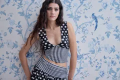 Top corto de lycra y algodón con estampado de lunares en blanco y negro en la parte superior y rayas verticales en blanco y negro en la parte inferior. Escote en V.