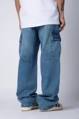 Pantalón jean azul de corte ancho, estilo cargo, con bolsillos laterales y detalles metálicos.