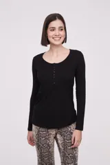 Remera de manga larga entallada en color blanco, confeccionada en algodón. Presenta cuello redondo con una hilera de botones frontales y un pequeño bolsillo en el pecho con detalle de botón.