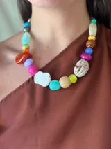 Collar corto con cuentas de cerámica, acrílico y piedras de diferentes colores. Se cierra con cadena de acero quirúrgico y ganchito para regular el largo.
