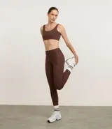 Pantalón deportivo tipo legging color marrón, de cintura alta y con bolsillos laterales funcionales.