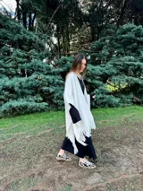 Zapatillas bajas con estampado animal print de vaca en blanco y negro, con cordones marrones y suela color caramelo.