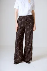 Conjunto de camisa y pantalón marrón con estampado de círculos blancos.