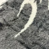 Sweater de punto negro con cuello redondo y diseño de llamas blancas.