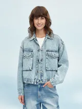 Campera de jean celeste con efecto lavado, corte cropped, cuello camisero, cierre frontal con botones metálicos, cuatro bolsillos frontales con solapa y puños abotonados.