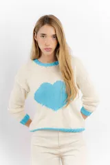 Sweater tejido de lana merino color crudo, con cuello, puños y ruedo acanalados en color celeste. Presenta un corazón celeste tejido en el frente.