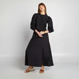 Blusa corta negra con bordado floral, mangas largas abullonadas y cuello redondo.