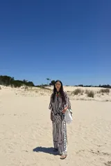 Pantalón largo de corte recto, color crudo con rayas verticales en negro.