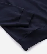 Buzo de algodón color azul marino, de manga larga y cuello polo con botones. Presenta puños y bajo ajustados.