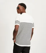 Polo de hombre con corte comfort, confeccionada en tejido de punto de algodón a rayas horizontales blancas y negras. Tiene cuello inglés con botones y mangas cortas.