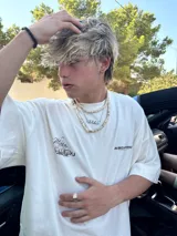 Remera amarilla con estampado en la espalda de una camioneta con una chica y una tabla de surf.