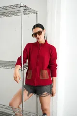 Campera tejida con textura vanizada a rayas horizontales en blanco y negro, con cierre frontal y flecos negros en forma de V en el pecho.