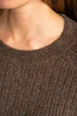 Sweater color beige de tejido texturado, con cuello redondo y mangas largas.