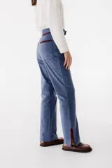 Pantalón de pana marrón con corte acampanado y abertura en el ruedo.
