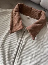 Campera de pana color crudo con cierre y bolsillos.
