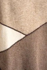 Sweater de tejido de punto con diseño de bloques de color en tonos beige, blanco roto y bordó. Presenta cuello redondo y mangas largas.