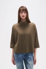 Polera holgada de poliéster color verde militar, con cuello alto tipo tortuga y mangas tres cuartos.