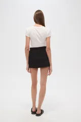 Minifalda negra de algodón con cintura elástica y bolsillos frontales.