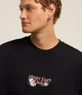 Remera negra de corte oversized con estampa en la espalda con la frase "Heart Eyes Only" y un oso cupido.