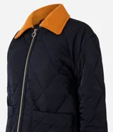 Campera puffer negra con cuello de terciopelo color mostaza, cierre frontal con cremallera y bolsillos laterales.