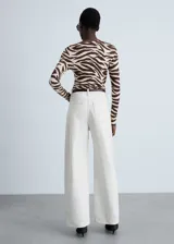 Camiseta de manga larga con estampado animal print de cebra en tonos marrones y beige. Tiene cuello asimétrico y corte ajustado.