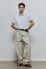 Remera polo blanca de punto de algodón liviano, corte slim fit, con cuello, tapeta de botones y bajo recto.