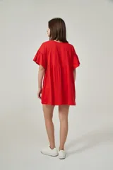 Vestido corto rojo coral, de corte holgado, con mangas cortas con volados y cuello redondo.