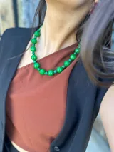 Collar corto con cuentas grandes de acrílico color verde esmeralda y cuentas pequeñas color verde agua. Se cierra con cadena de acero quirúrgico y ganchito para regular el largo.